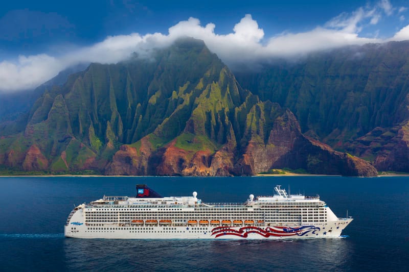 Pride of America cruise ship in Hawaii waters sailing along Na Pali coast in the background.