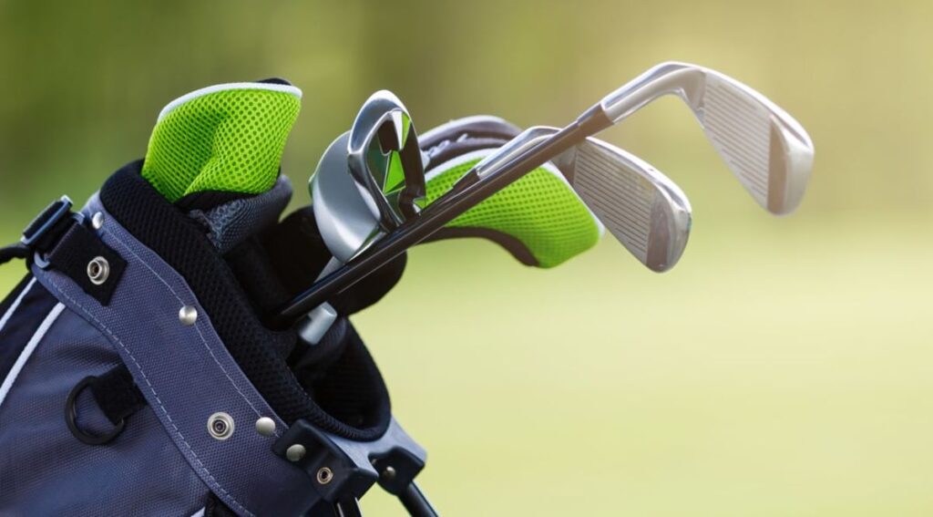 Golf clubs in golf bag with green color golf club covers